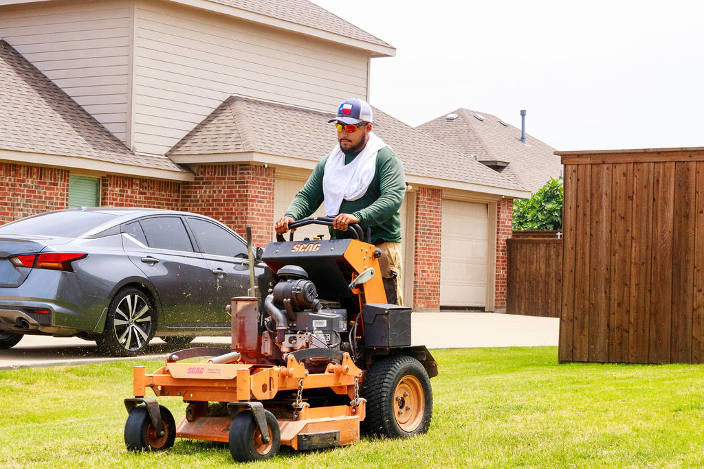 Riding lawn mower cutting grass.